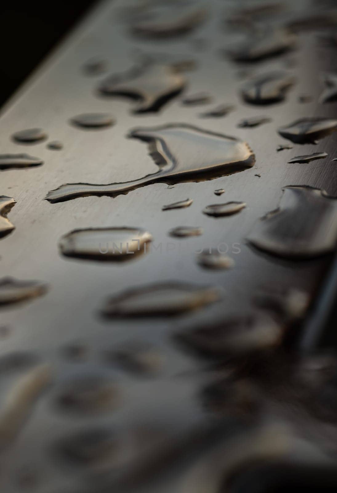 Close up of Rain water drops on the metallic surface. Water droplets caused by rain perched on a stainless steel handle, Natural Pattern of raindrops or dew drops on silver metal background for wallpaper poster and banner design, Selective focus.