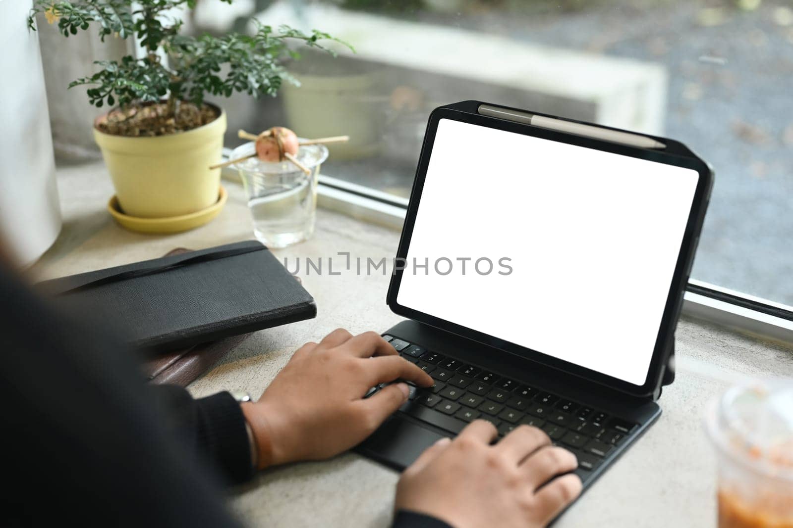 Close up image of businesswoman typing on keyboard of digital tablet.