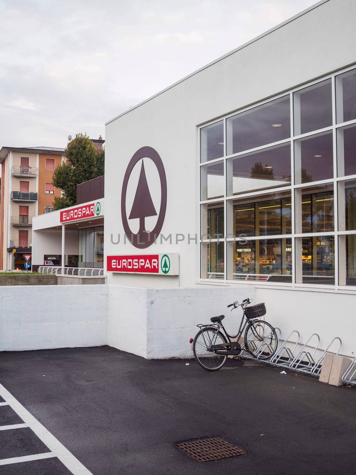 Cremona, Italy September 26th 2024 A bicycle is parked in front of a eurospar supermarket building with large windows