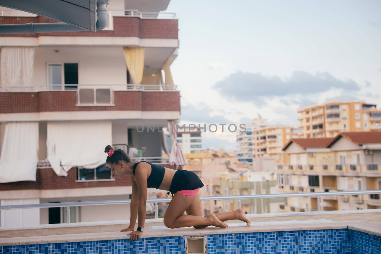 In an urban environment, a dedicated fitness enthusiast engages in exercising activities near a vibrant pool
