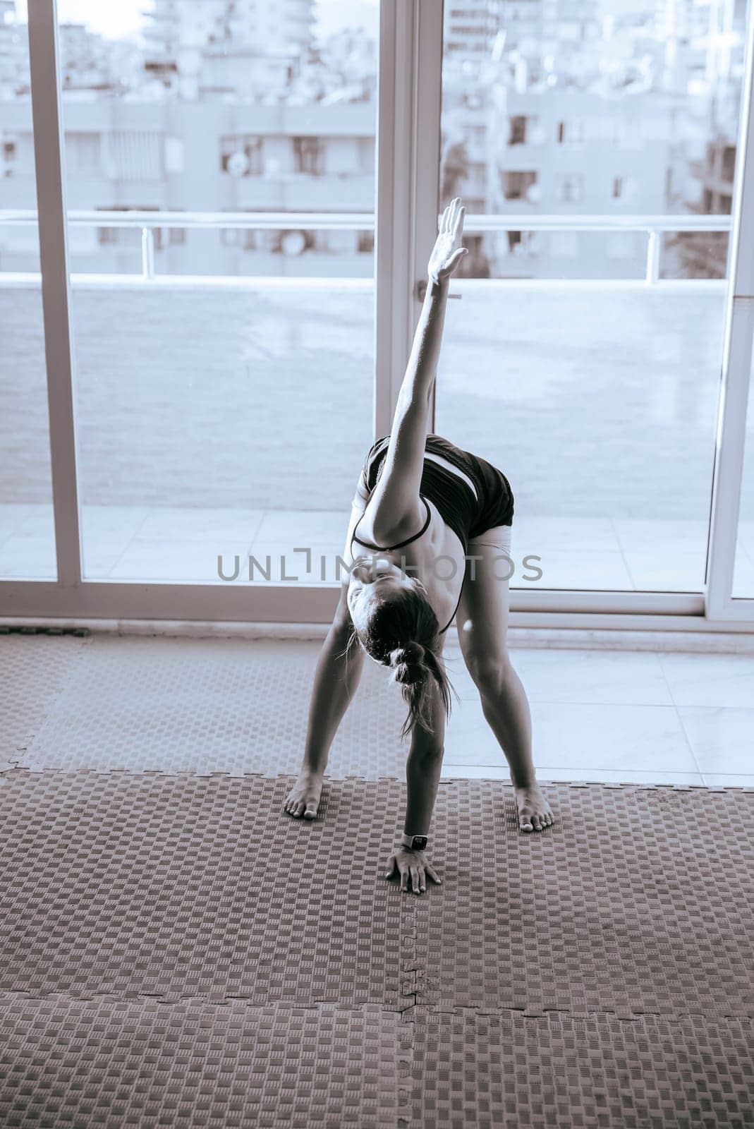 A graceful figure practicing yoga poses in a modern and stylish space, showcasing flexibility and tranquility