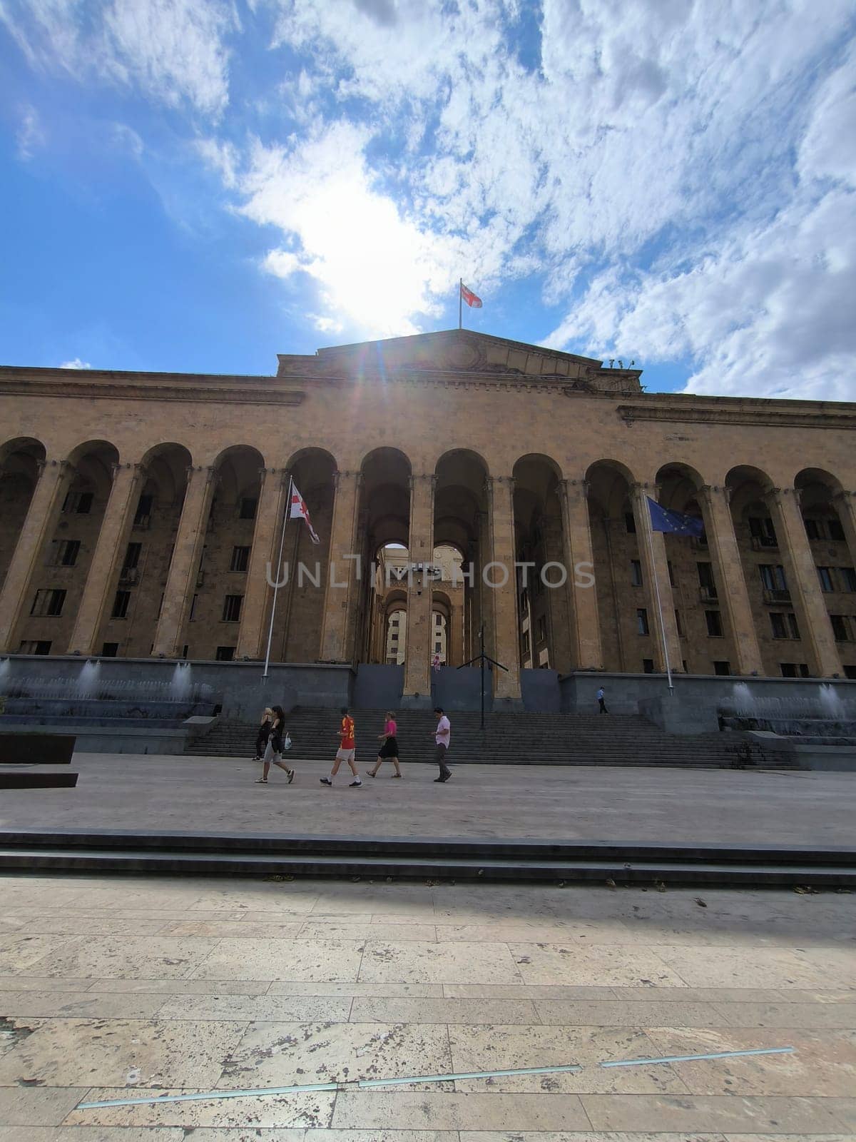 18 August 2024 Tbilisi Georgia modern building in the city center, gray stone stre fontaine, flag. High quality photo