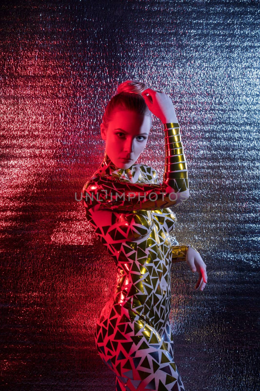 Beautiful blonde with gold tape body art shot against silver wall