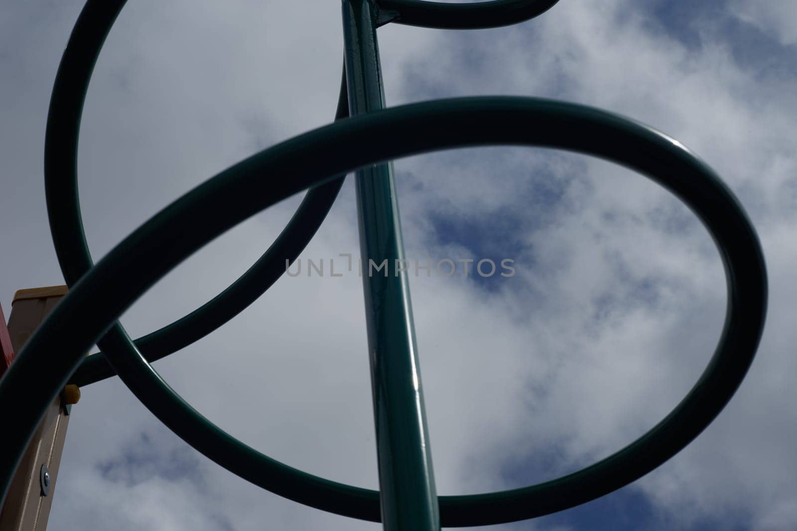 A playground for climbing a metal pipe, against a blue sky background. Outdoor sports games.