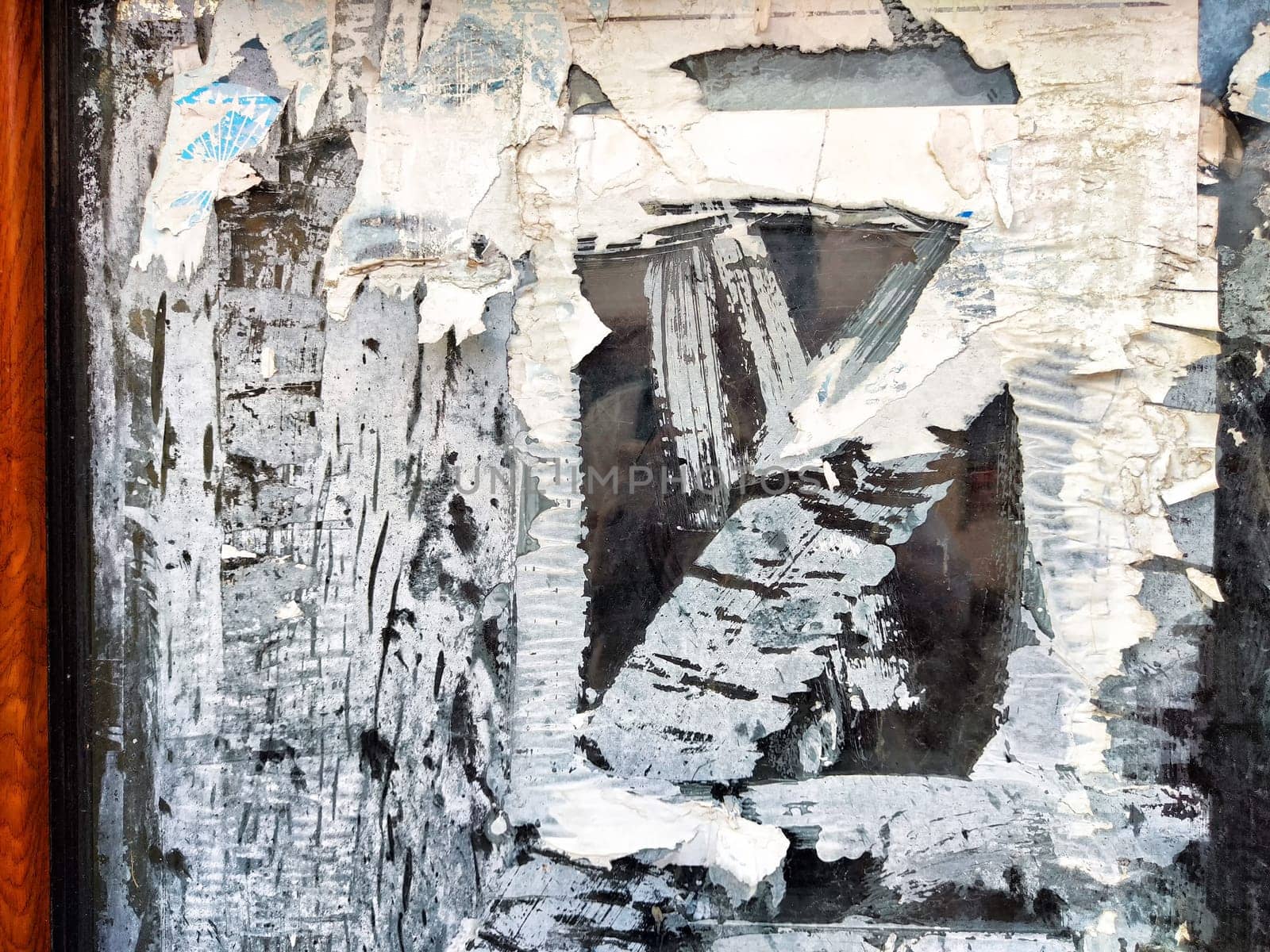Layers of peeling paint expose a weathered surface, illustrating urban decay and the passage of time in an abandoned area.