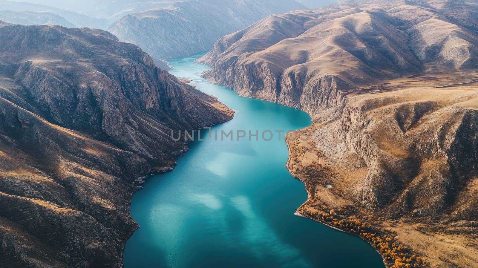 A serene river twists through rugged mountains under early morning light, showcasing vibrant turquoise water and dramatic rock formations along the banks.