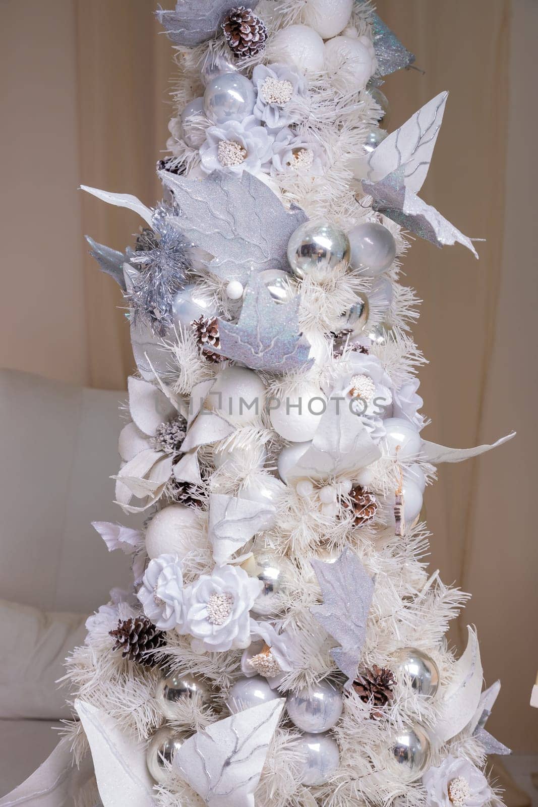 Decorated gold Christmas tree with golden patchwork ornament artificial star hearts presents for new year in white interior