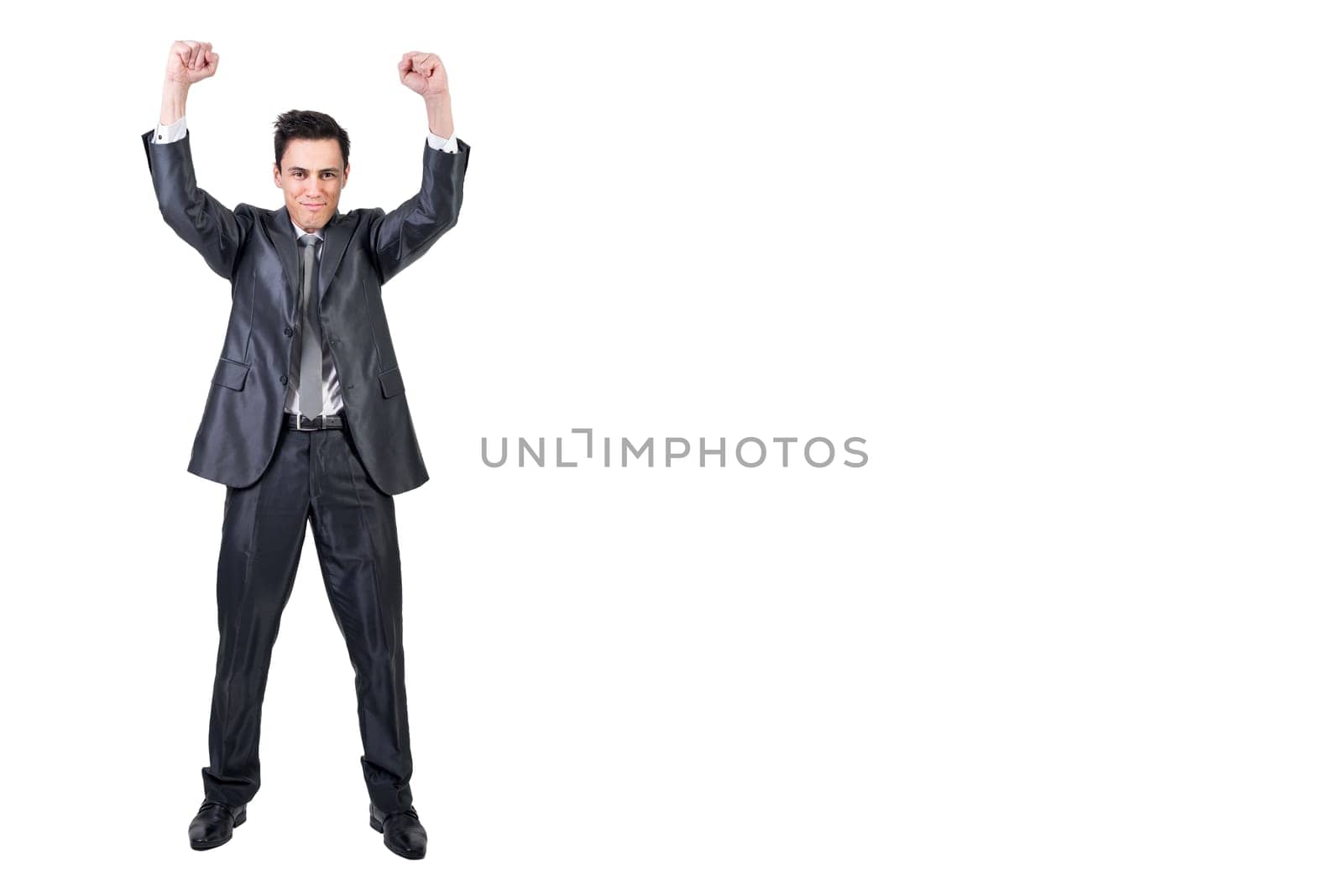 Full body of positive male in formal suit raising clenched fists and looking at camera while celebrating victory isolated on white background in studio
