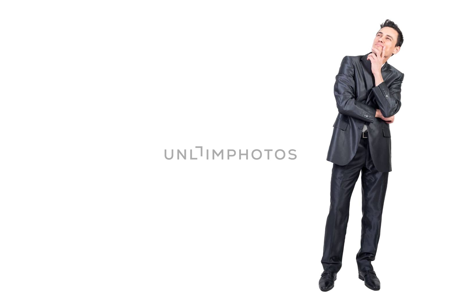 Full length of content pensive male entrepreneur in suit touching chin and looking up on white isolated background