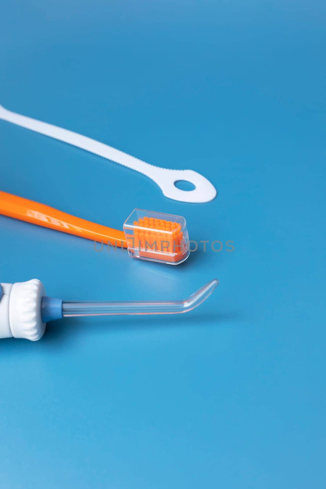 Dental Cleaning Set, Oral Hygiene. Toothbrush, Oral Irrigator, Floss, Tongue Scraper On Blue Background. Flat Lay Of Dental Care Tools, Tooth Hygienic Equipment. Vertical Plane. Copy Space For Text