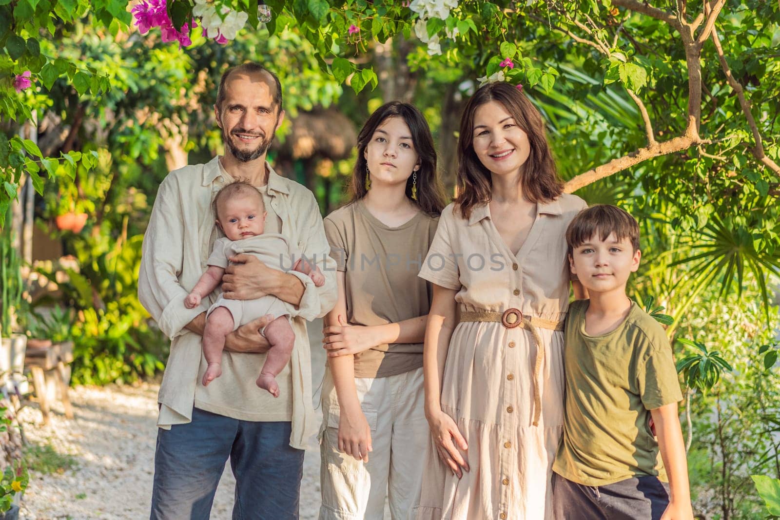 Happy couple in their 40s, surrounded by adult children, cradle a newborn in a sunlit park. Love, family, and generations in harmony.