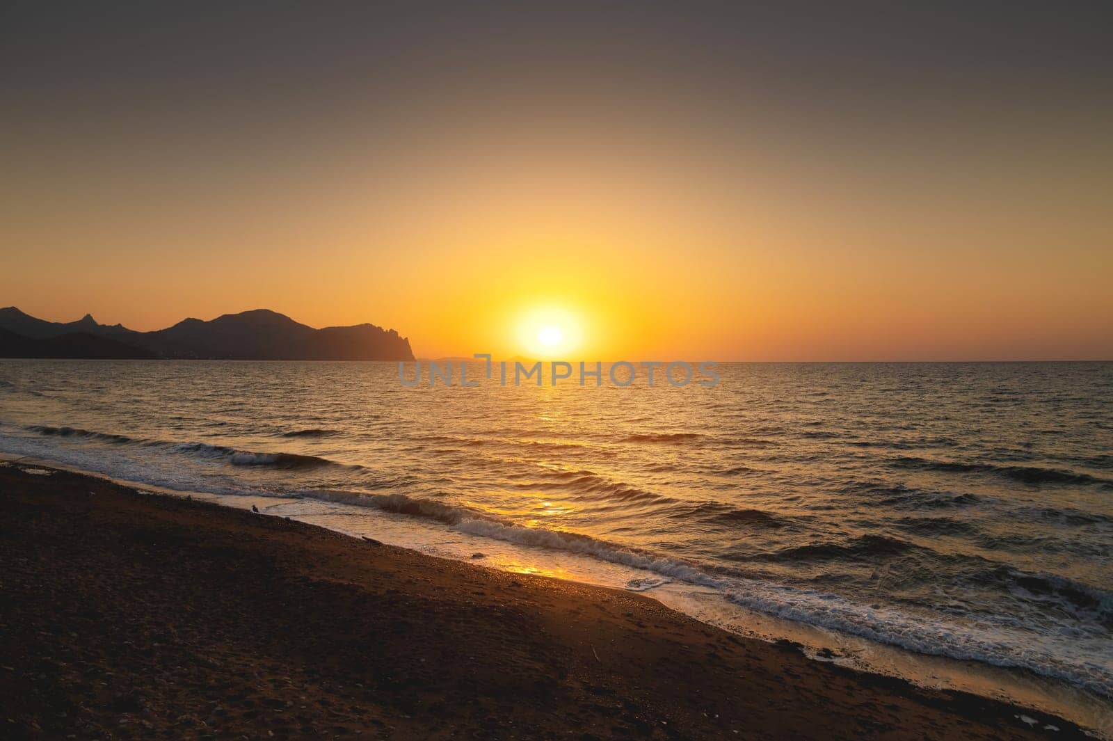 Beautiful sunrise over the sea. A serene beach at sunset, golden rays casting a warm glow on the sand and gently crashing waves.