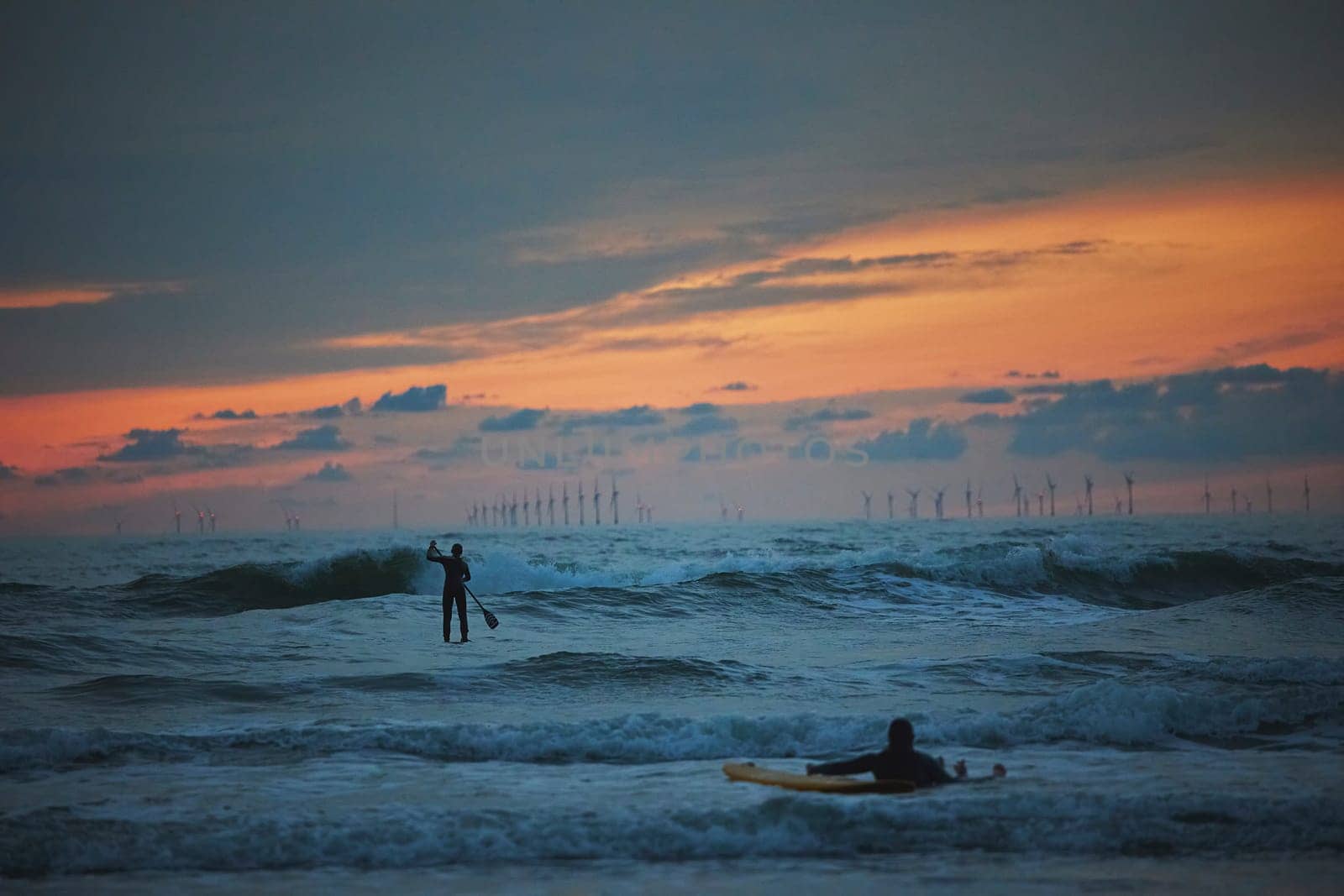 Surfer in the North Sea in the Netherlands at night.