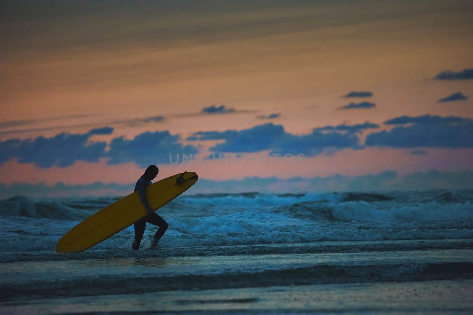 Surfer in the North Sea in the Netherlands at night by Viktor_Osypenko