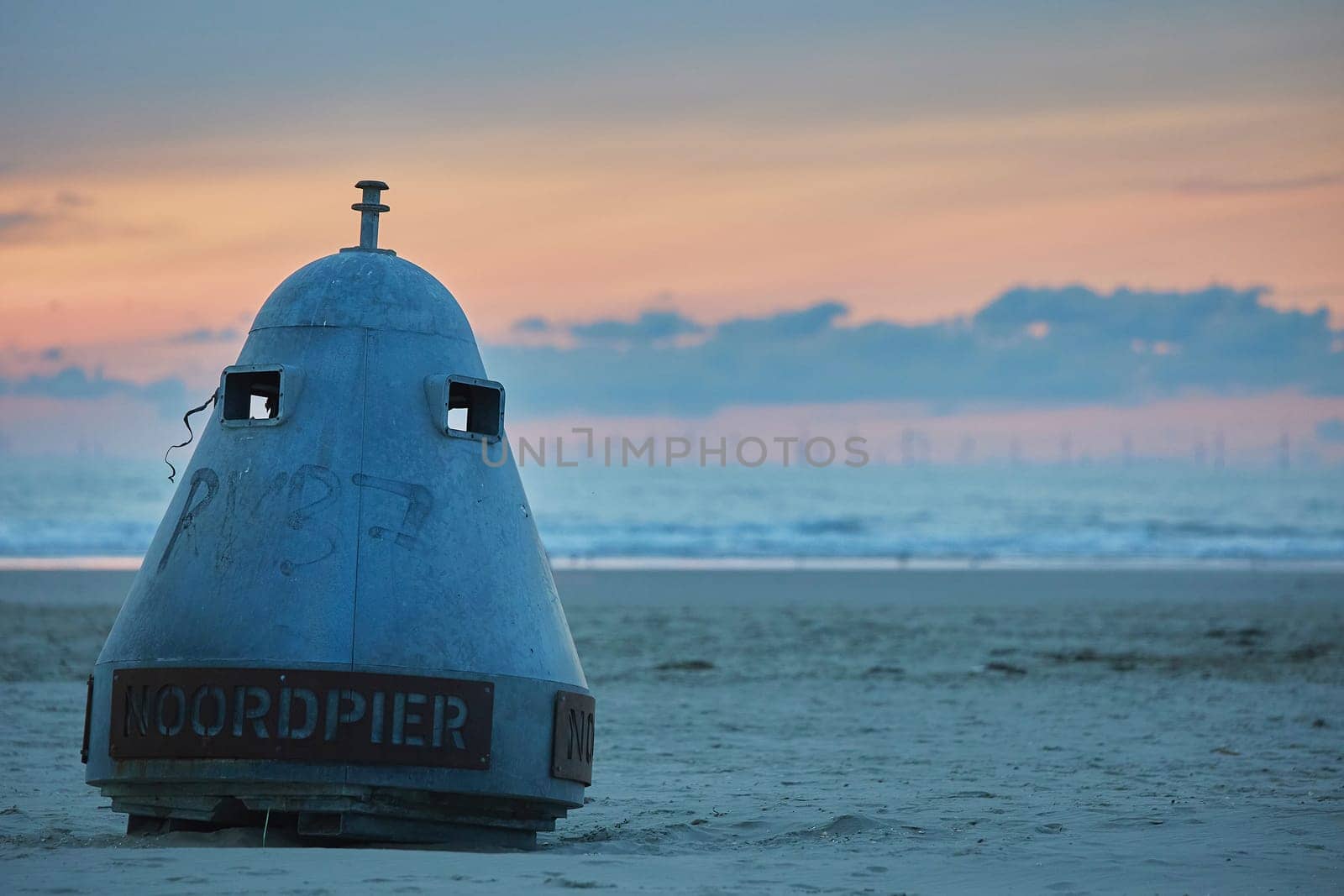 Buoy on a north sea beach in the Netherlands at sunset by Viktor_Osypenko