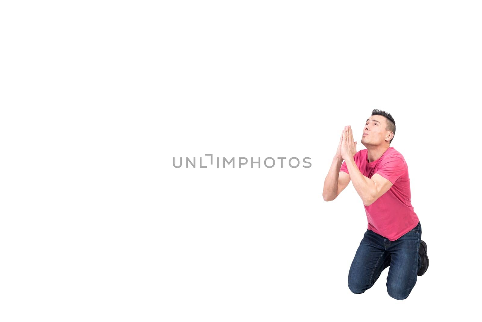 Full body of male with prayer hands kneeling and begging for help while looking up with hope on white background
