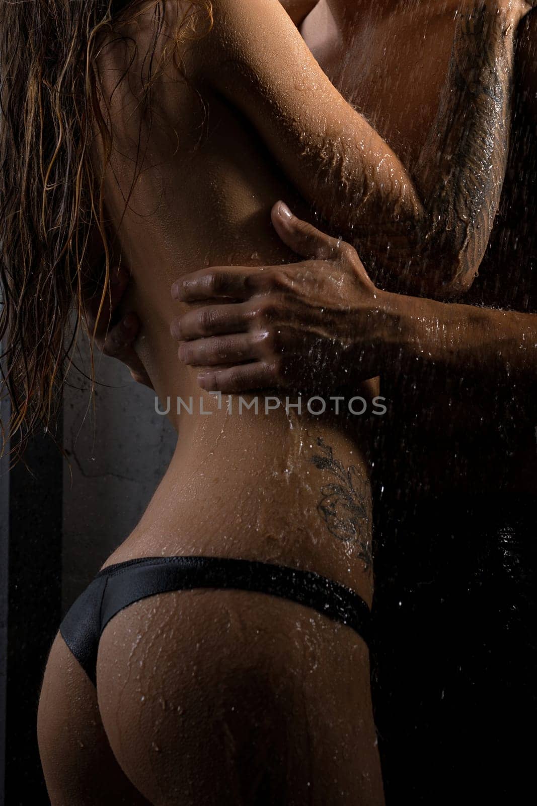 Shirtless man and girl topless embracing in shower view