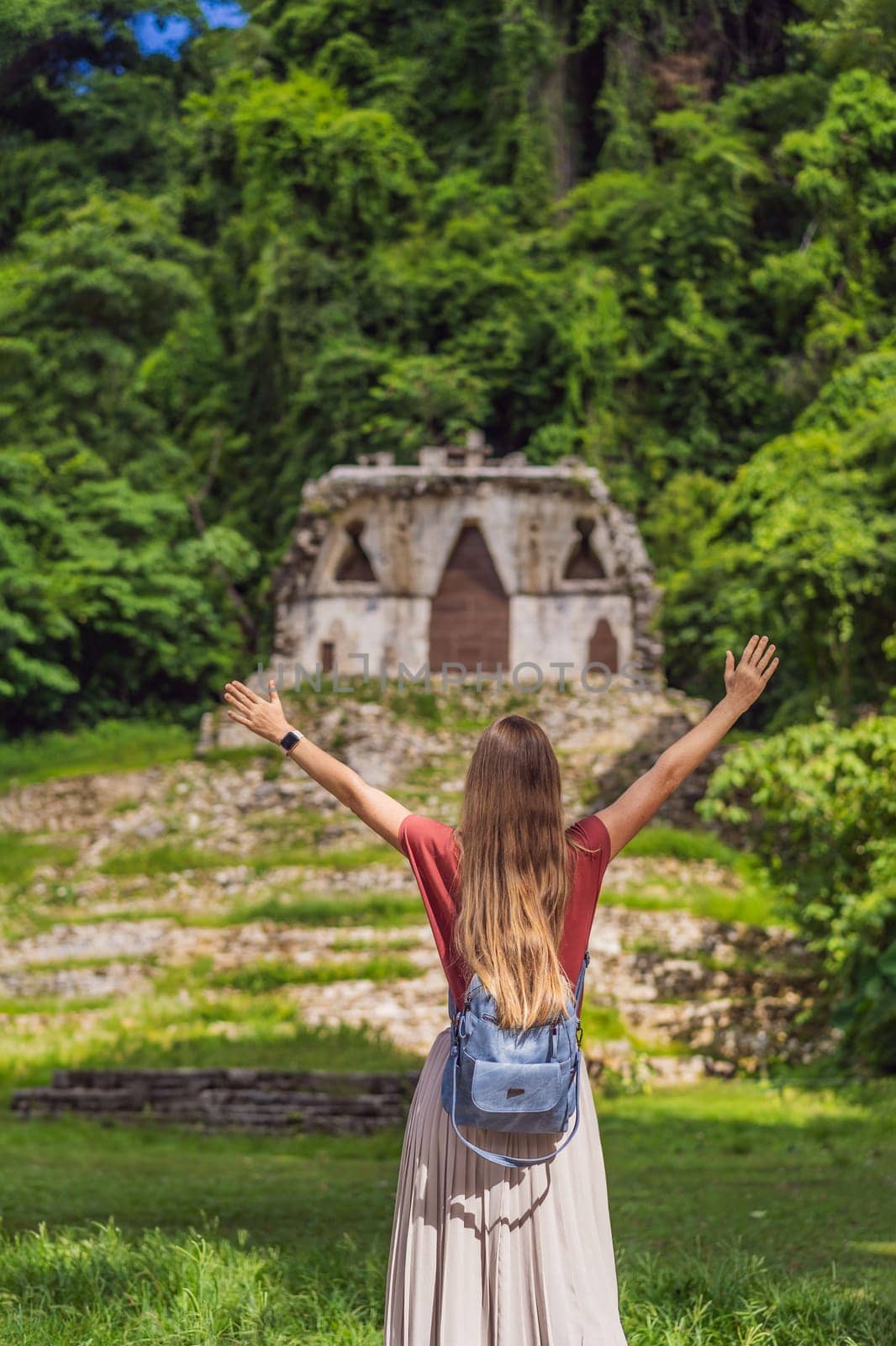 Female tourist exploring the ancient pyramids of Palenque, Mexico, surrounded by dense jungle. Cultural heritage and adventure travel concept.
