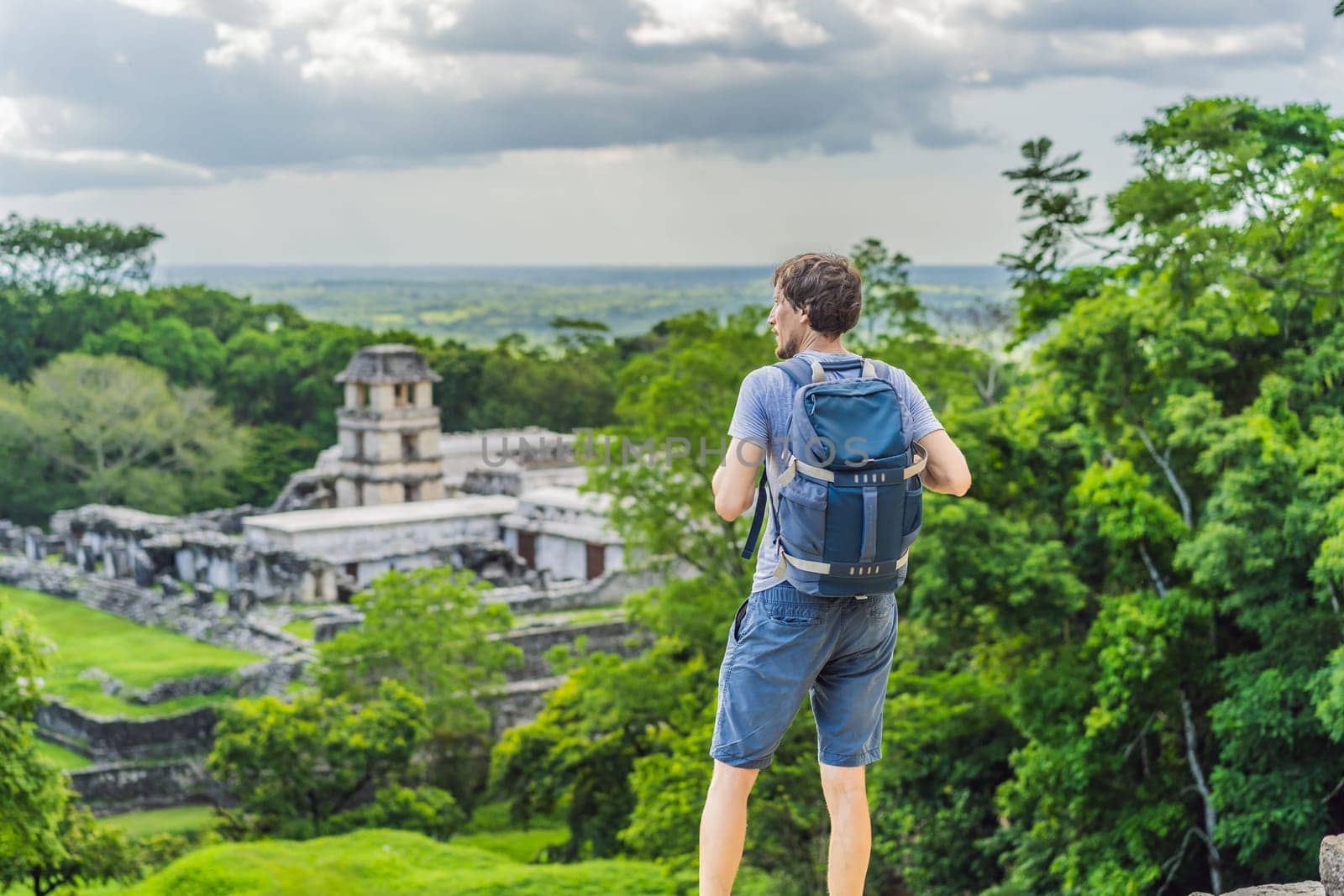 Man tourist exploring the ancient pyramids of Palenque, Mexico, surrounded by dense jungle. Cultural heritage and adventure travel concept.