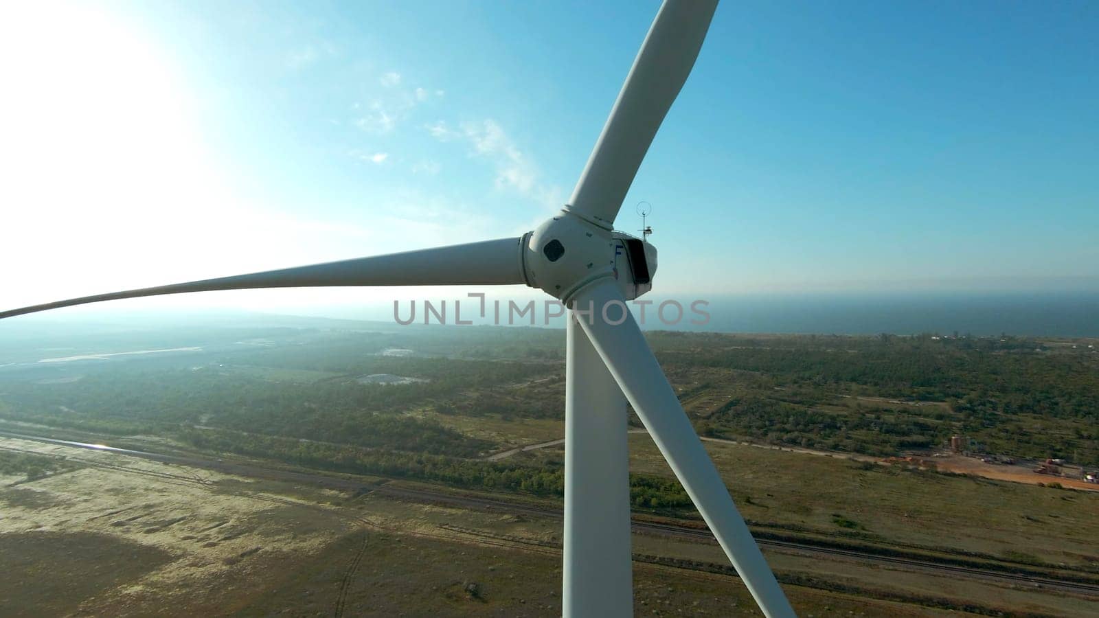 Top view of windmill on horizon background. Shot. Beautiful landscape with windmill at dawn. Modern wind turbine on background of summer landscape.