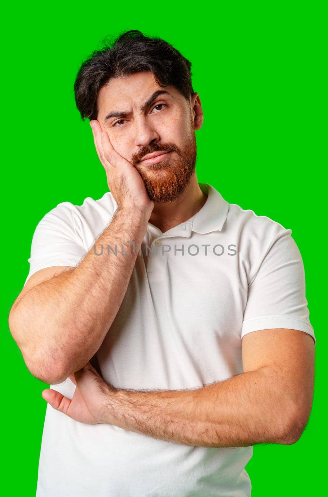 A man with a serious expression stands against a vibrant green background in studio