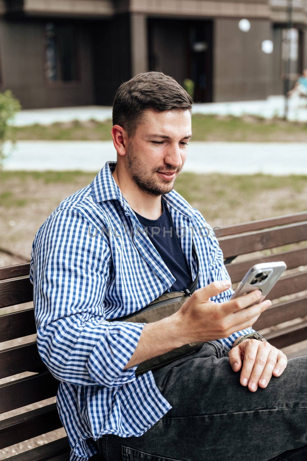 Young man sitting on a bench in a park close up