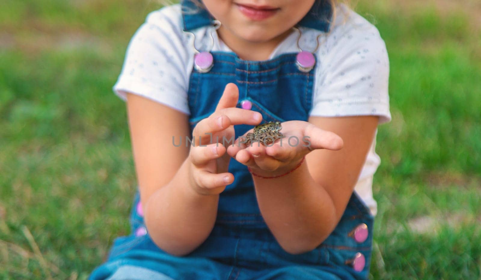 A child looks through a magnifying glass in nature. Selective focus. kid,