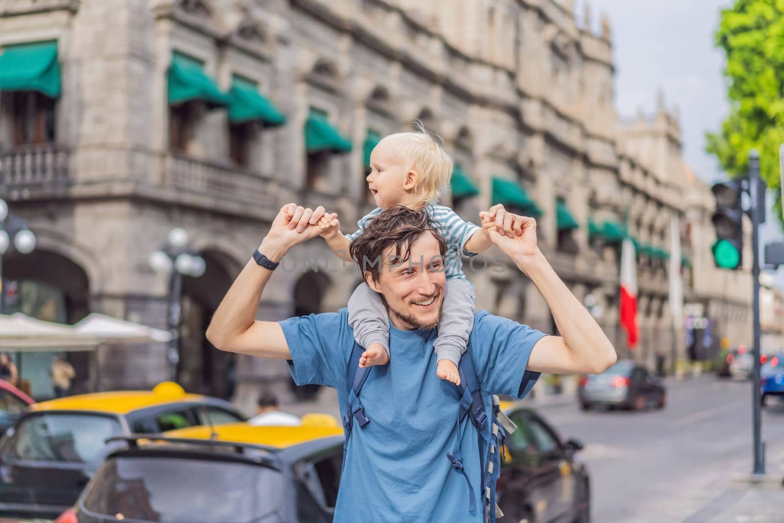 Father tourist with his toddler son walking through the colorful colonial streets of Puebla, Mexico. Travel, cultural exploration, and vibrant architecture concept.