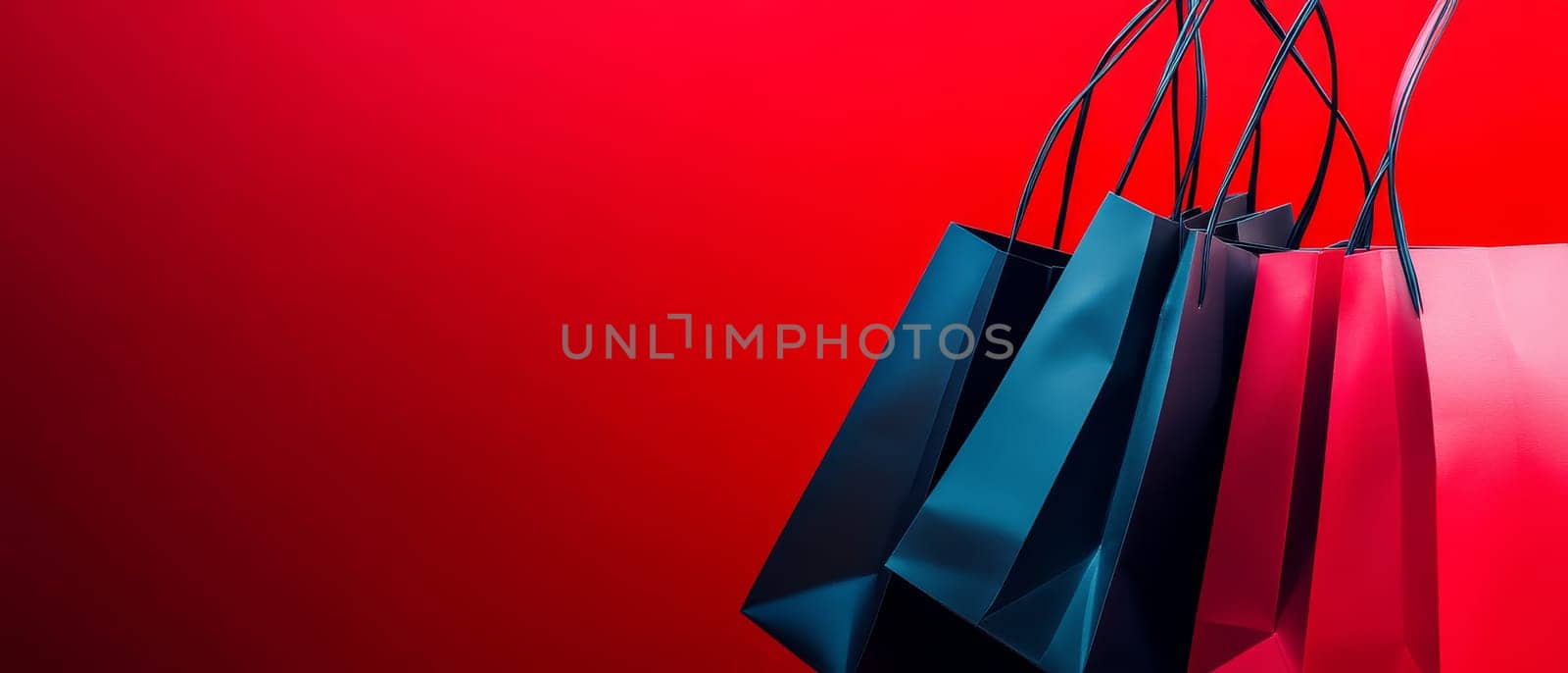 Stylish shopping bags in blue, navy, and pink colors arranged on vibrant red background with copy space, perfect for sale or retail concepts.