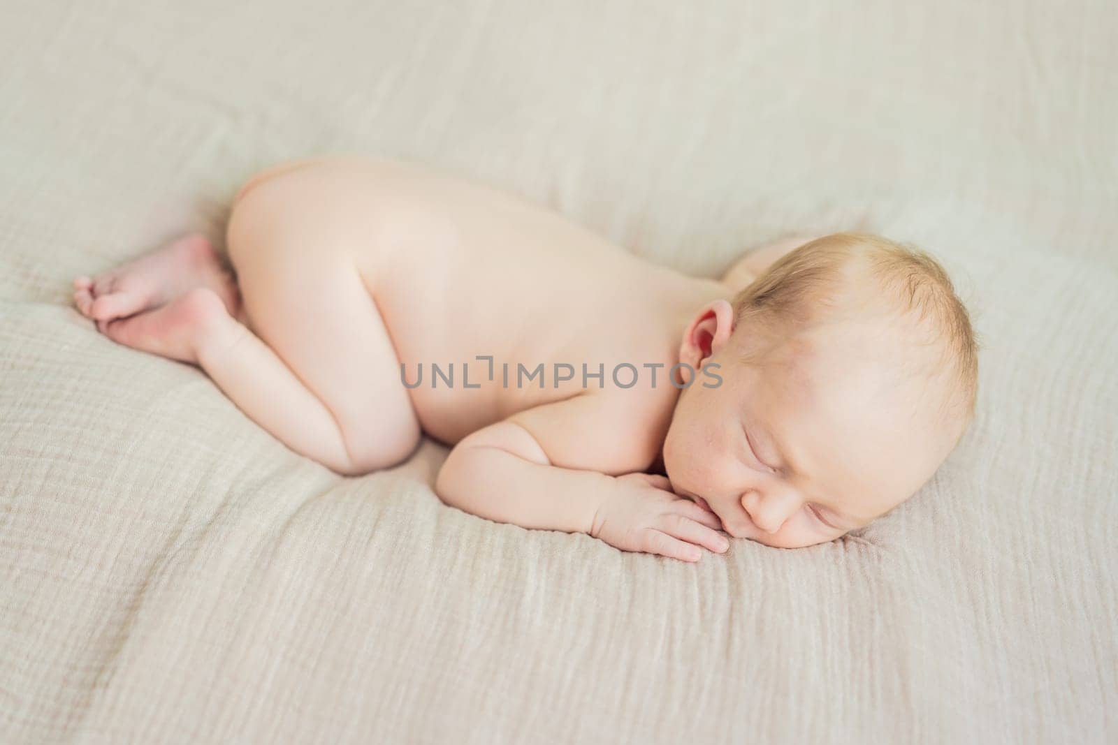 The baby is sleeping peacefully in his cozy nest. Newborn photo session captures the serene innocence and warmth of early moments.