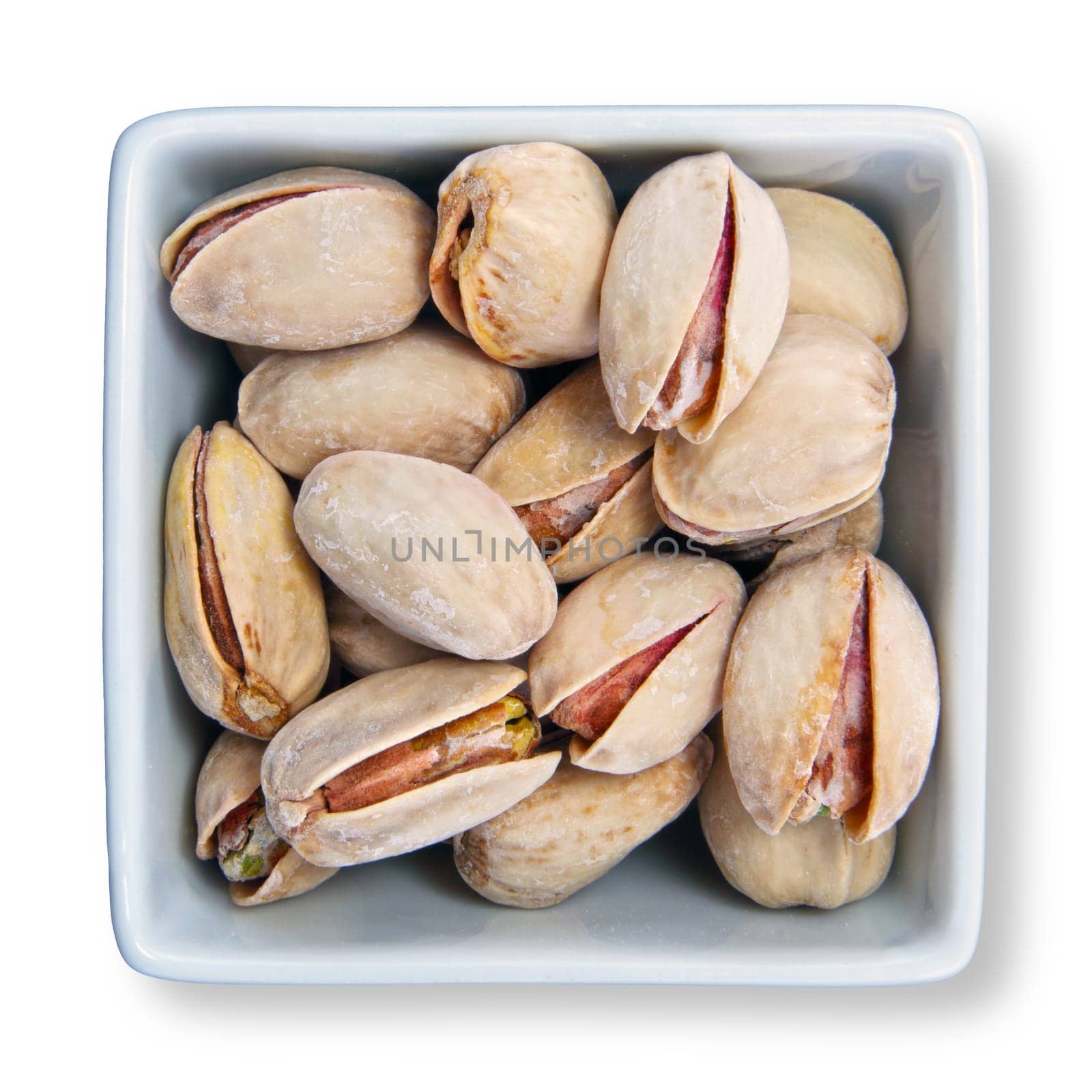 Pistachio nuts in shells in white container with clipping path to remove shadow