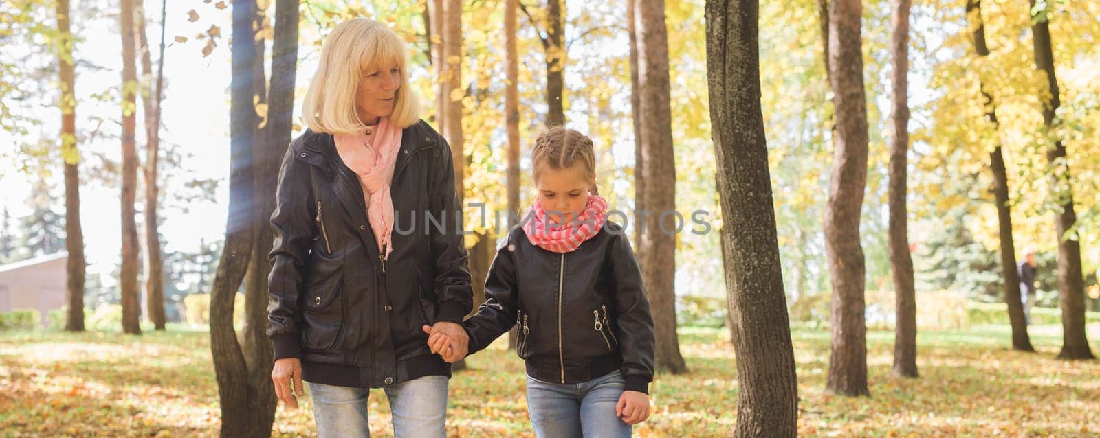 Grandmother with granddaughter in autumn park banner copy space. Generation and family concept. by Satura86