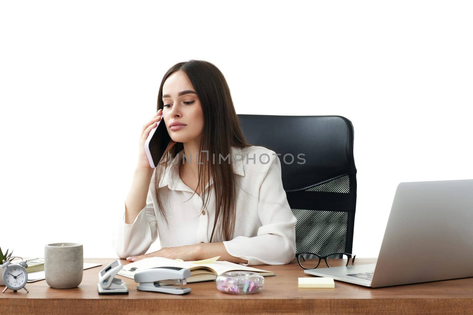 attentive businesswoman working with laptop and having phone conversation with client
