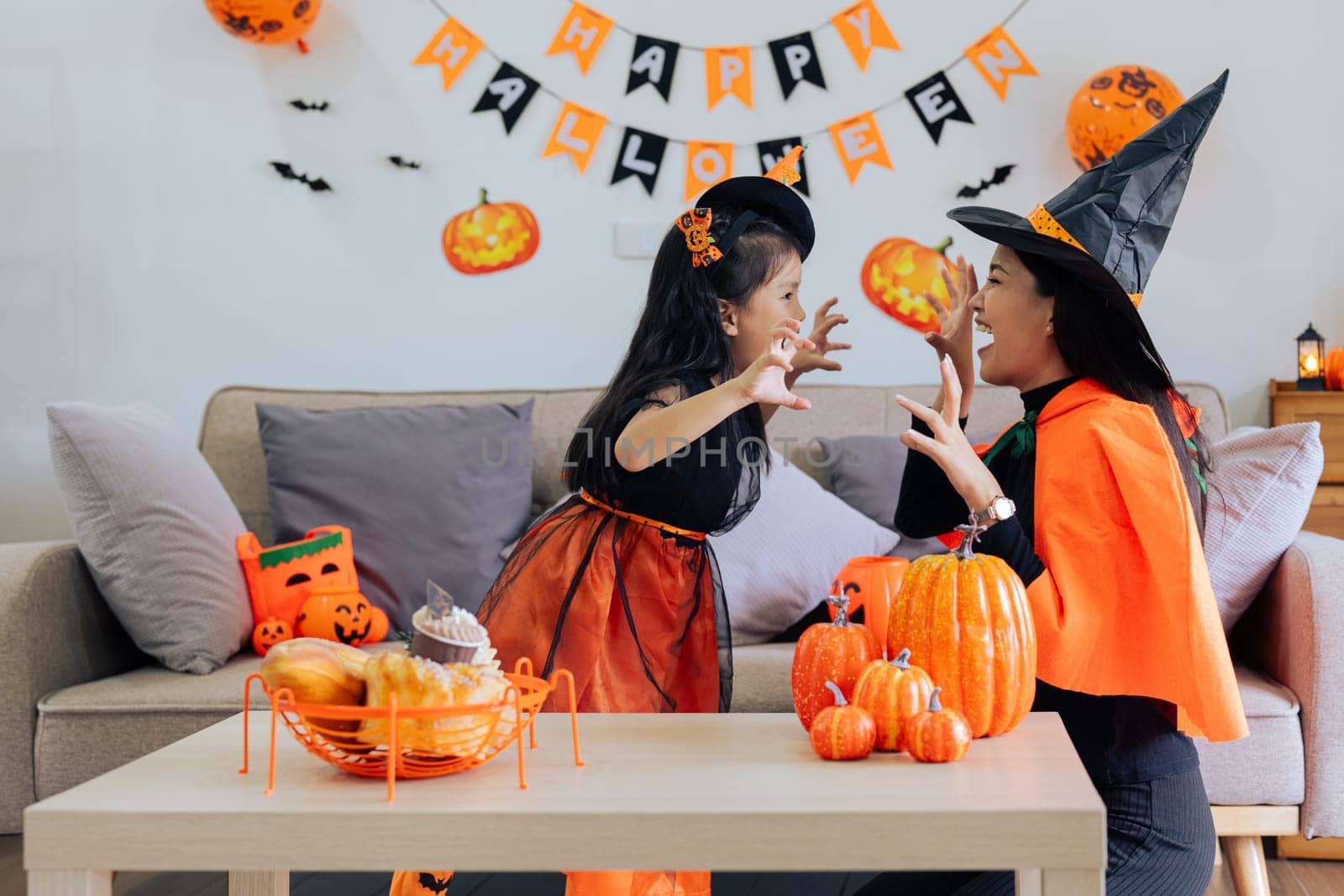 Mother and her daughter having fun at home. Happy Family preparing for Halloween by itchaznong
