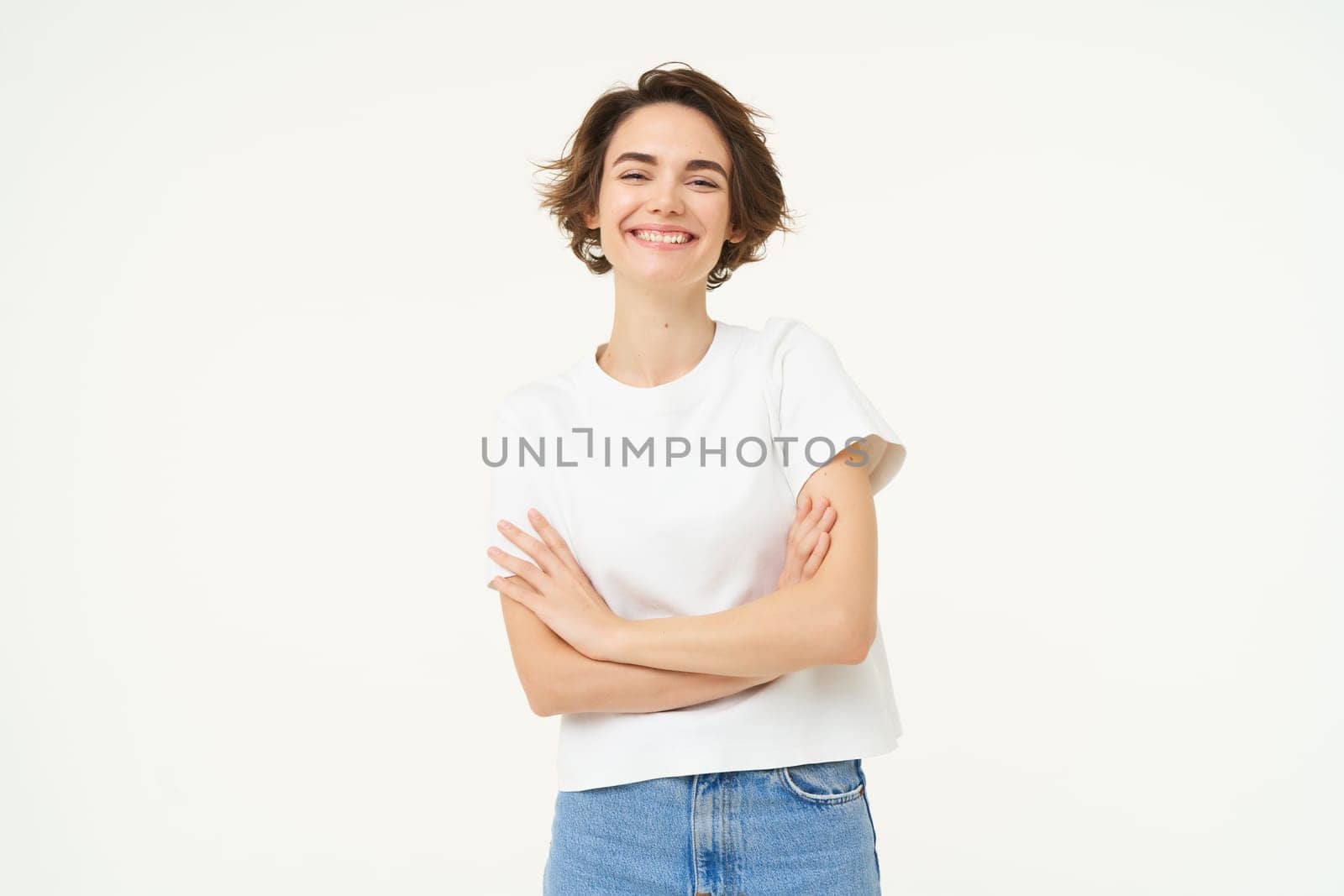 Portrait of cheerful woman laughing and smiling, cross arms on chest, standing in confident power pose, young professional concept, white studio background.