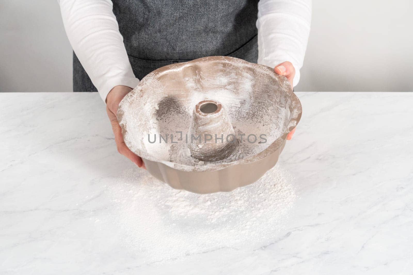 Greasing metal bundt cake pan to red velvet bundt cake with cream cheese glaze.