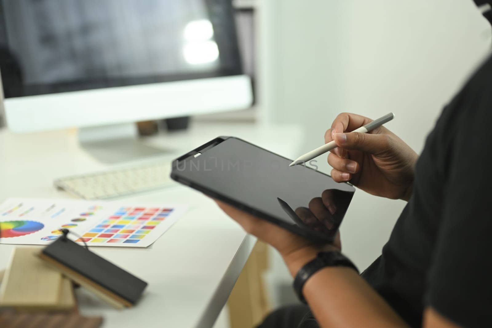 Cropped shot male designer or or creative professional using digital tablet and stylus to work on a digital project.
