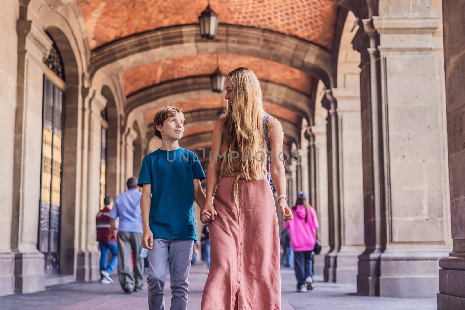 Mother and teenage son tourists in the central square of Mexico City, Zocalo. Family travel, cultural exploration, and historic architecture concept.