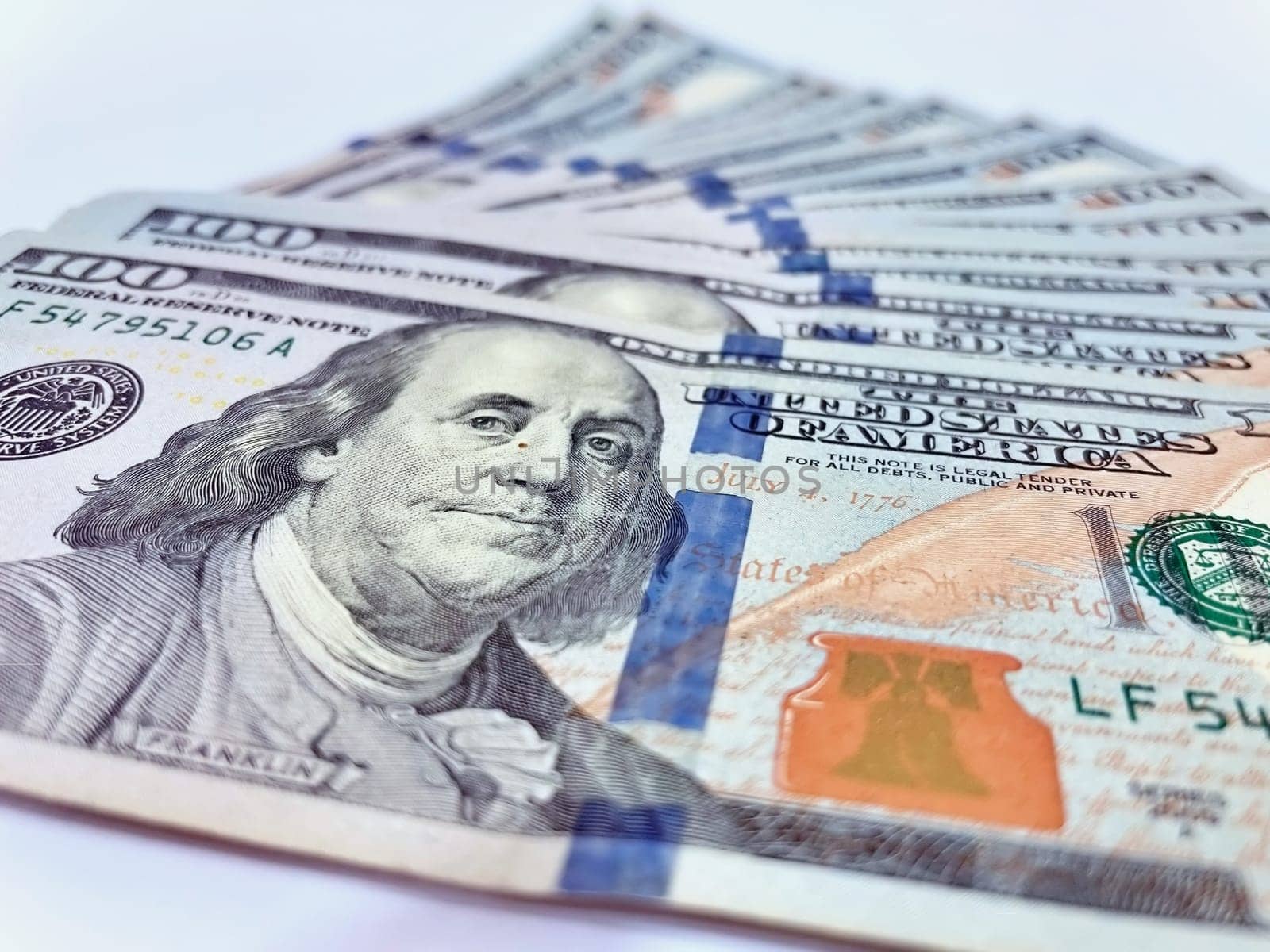 A Fan of $100 Bills.A close-up photo of a fan of $100 US dollar bills. The bills are arranged neatly, with the portrait of Benjamin Franklin visible on each bill. The background is white.Finance ve economy concept.