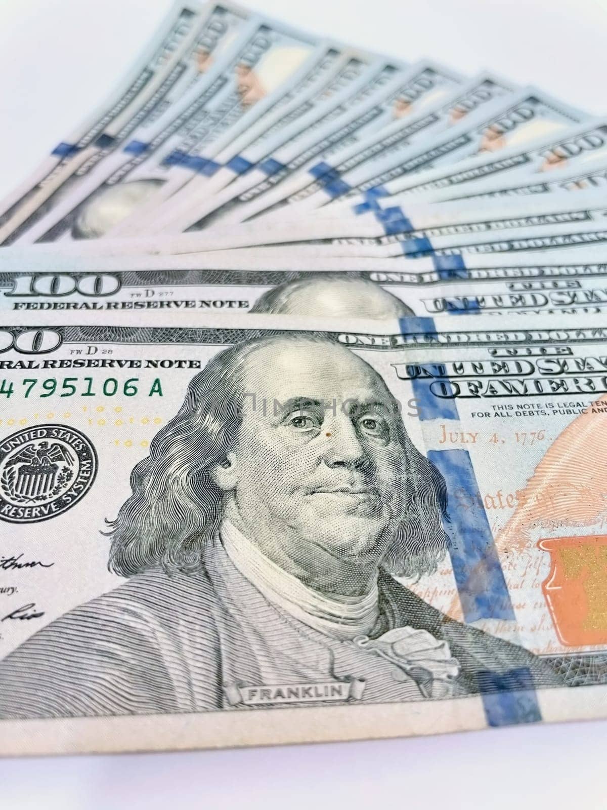 A Fan of $100 Bills.A close-up photo of a fan of $100 US dollar bills. The bills are arranged neatly, with the portrait of Benjamin Franklin visible on each bill. The background is white.Finance ve economy concept.