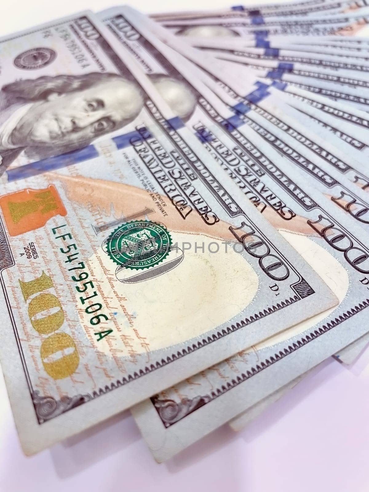 A Fan of $100 Bills.A close-up photo of a fan of $100 US dollar bills. The bills are arranged neatly, with the portrait of Benjamin Franklin visible on each bill. The background is white.Finance ve economy concept.