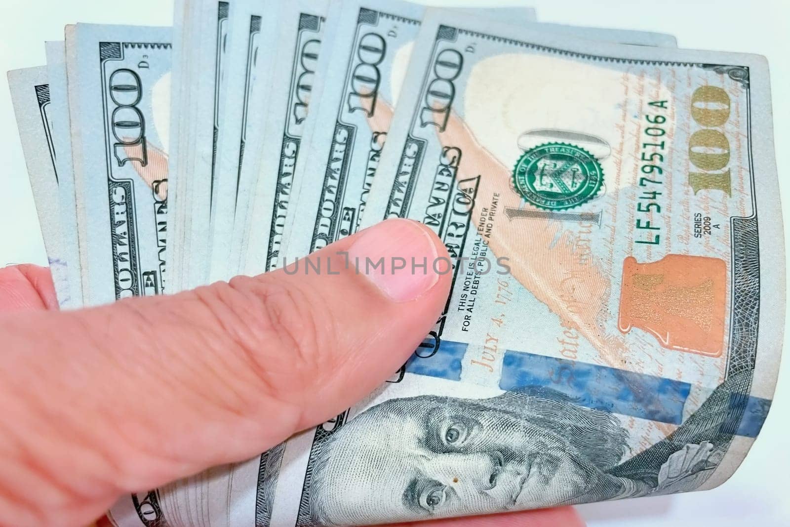 A Fan of $100 Bills.A close-up photo of a fan of $100 US dollar bills. The bills are arranged neatly, with the portrait of Benjamin Franklin visible on each bill. The background is white.Finance ve economy concept.