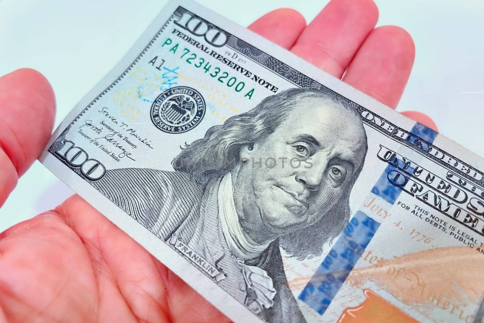 A Fan of $100 Bills.A close-up photo of a fan of $100 US dollar bills. The bills are arranged neatly, with the portrait of Benjamin Franklin visible on each bill. The background is white.Finance ve economy concept.