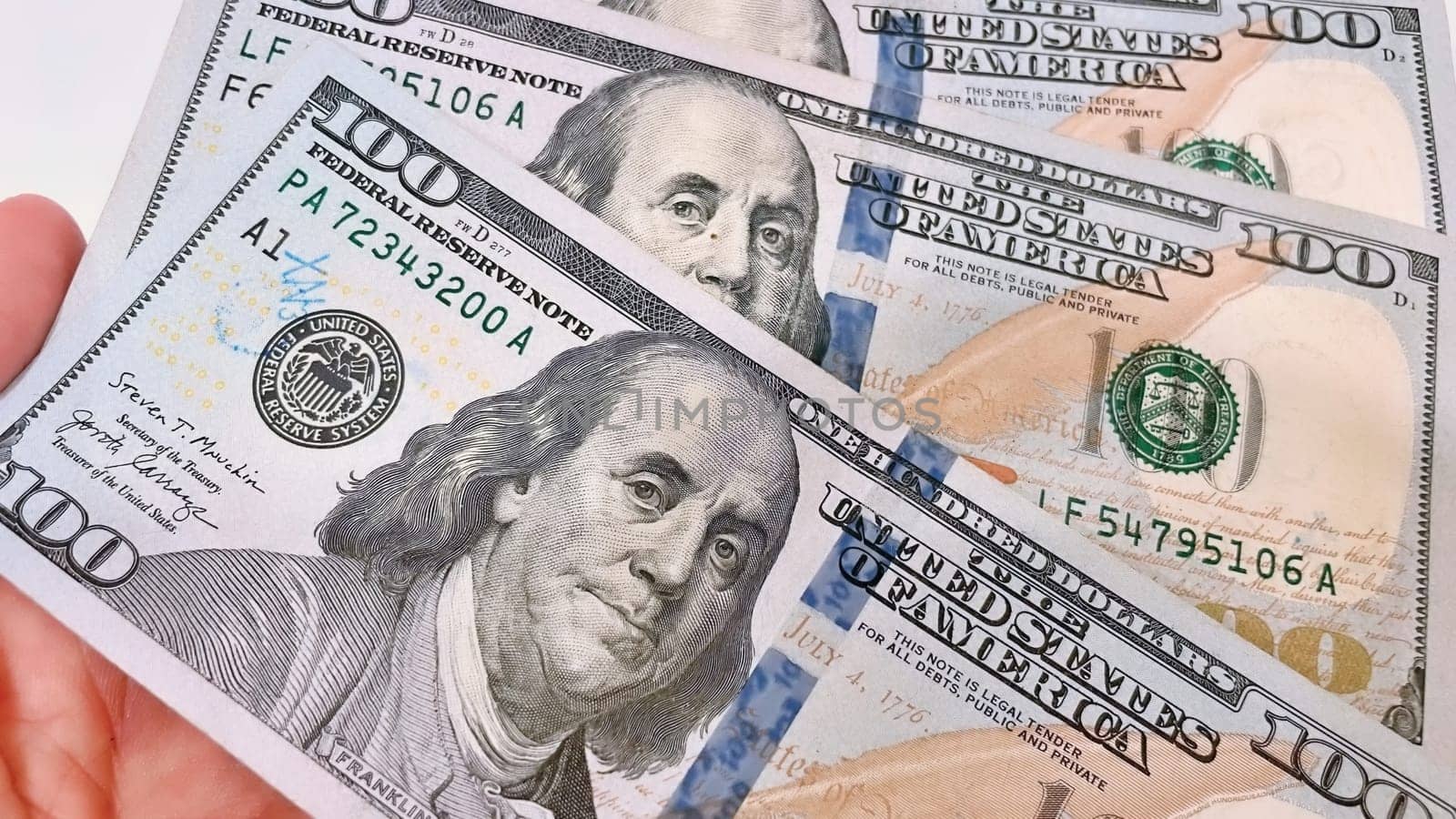 A Fan of $100 Bills.A close-up photo of a fan of $100 US dollar bills. The bills are arranged neatly, with the portrait of Benjamin Franklin visible on each bill. The background is white.Finance ve economy concept.