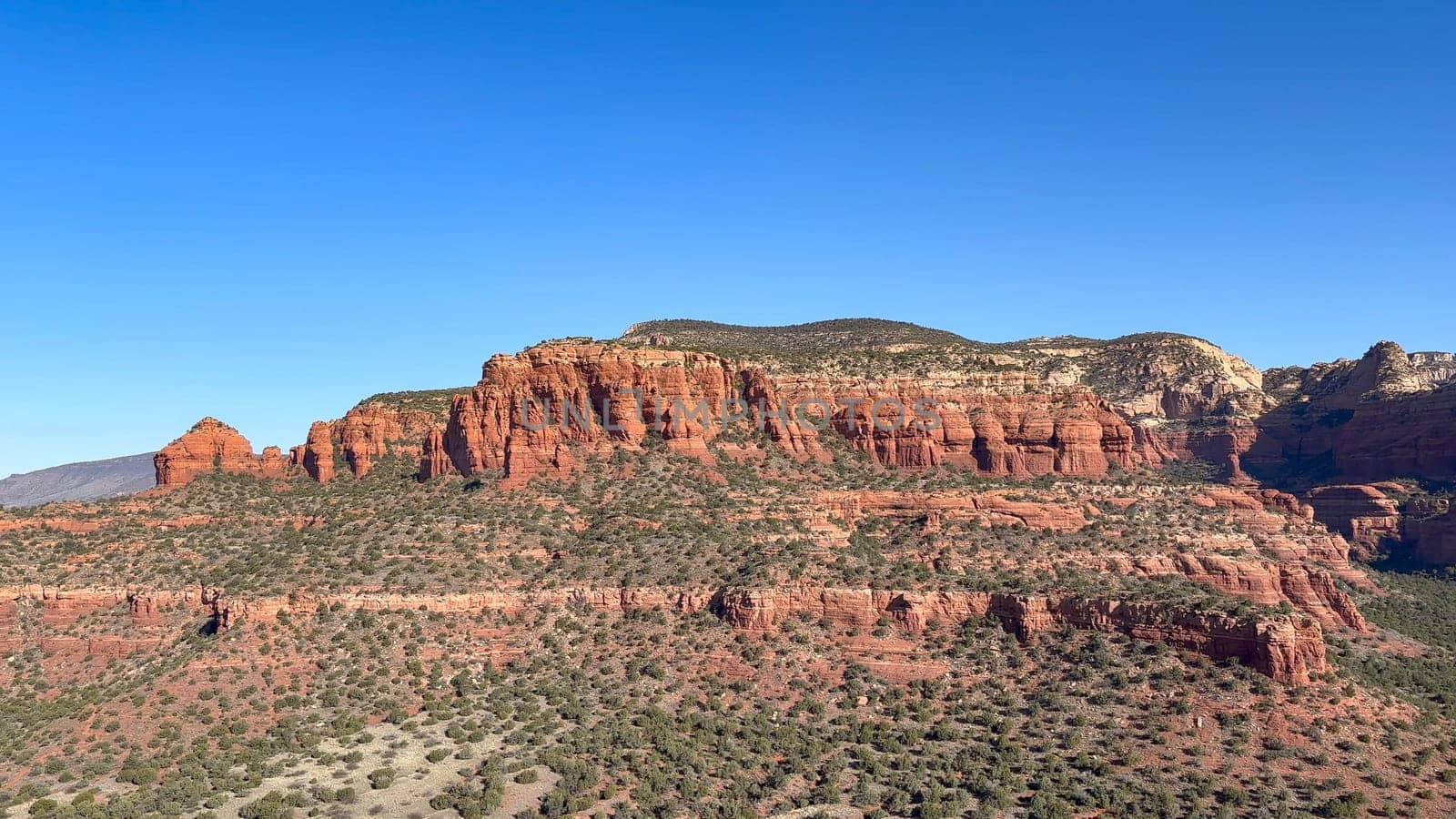 Beautiful aerial view of the iconic red rock formations of Bear Mountain in Sedona, Arizona. Capturing the rugged beauty of the desert landscape, with its towering cliffs and lush green trees - USA