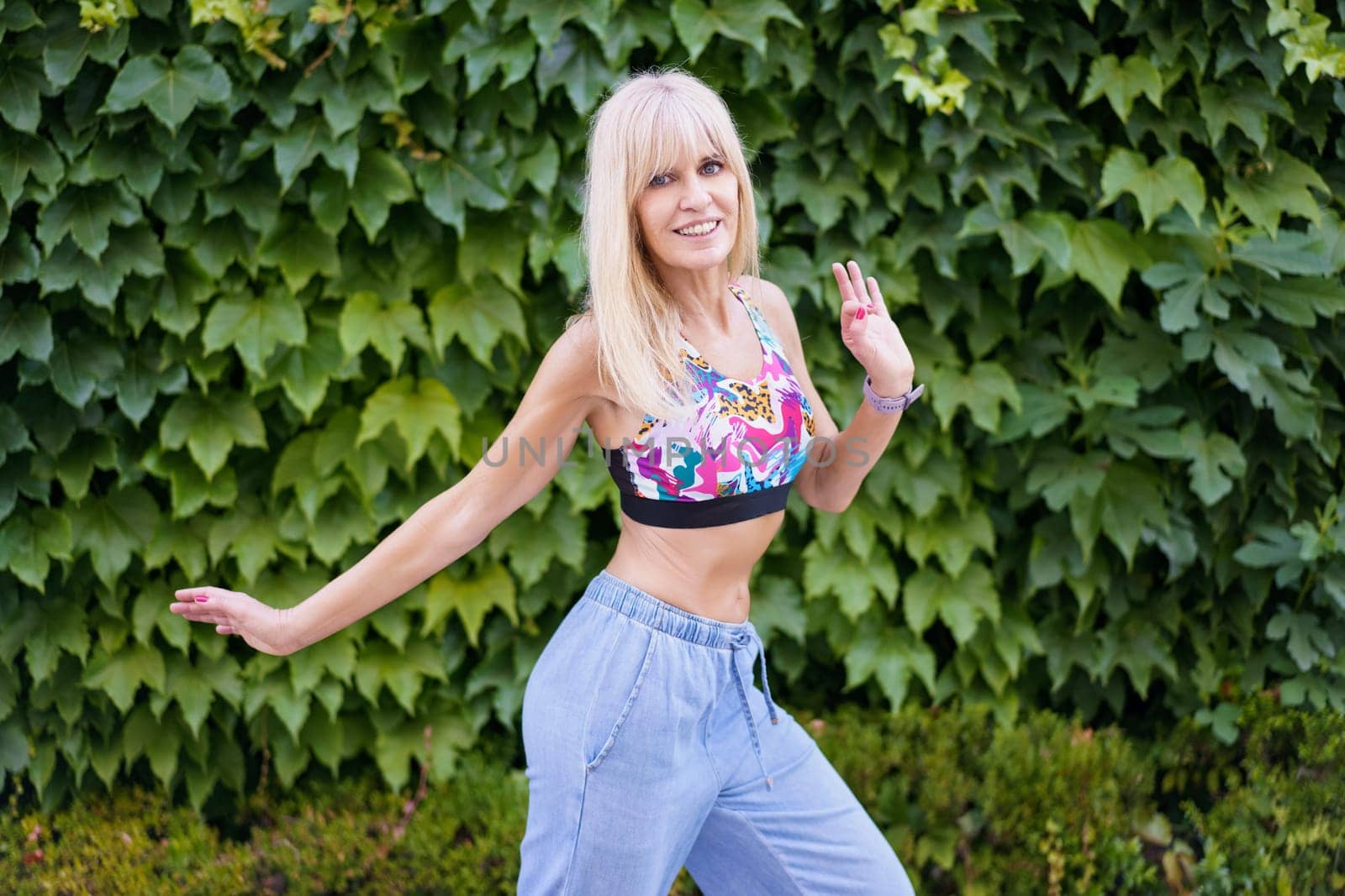 Female caucasian young professional dancer expressing movement through dance next to an urban garden