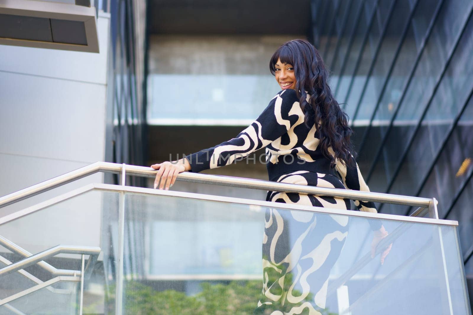 Sensual female hispanic dancer turning to look down from urban viewpoint of a building