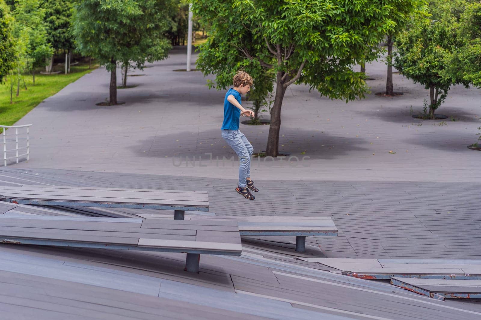 Teenage boy doing parkour in a park. Adventure, movement, and urban sport concept.