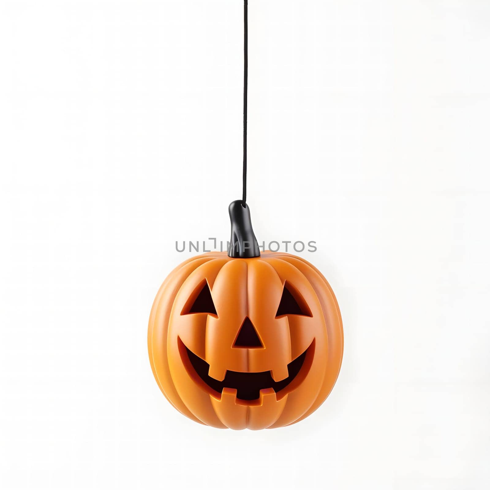 A carved jack-o-lantern, with a friendly grin, hangs from a string against a white background. The pumpkin's orange color and cheerful expression evoke the spirit of Halloween.