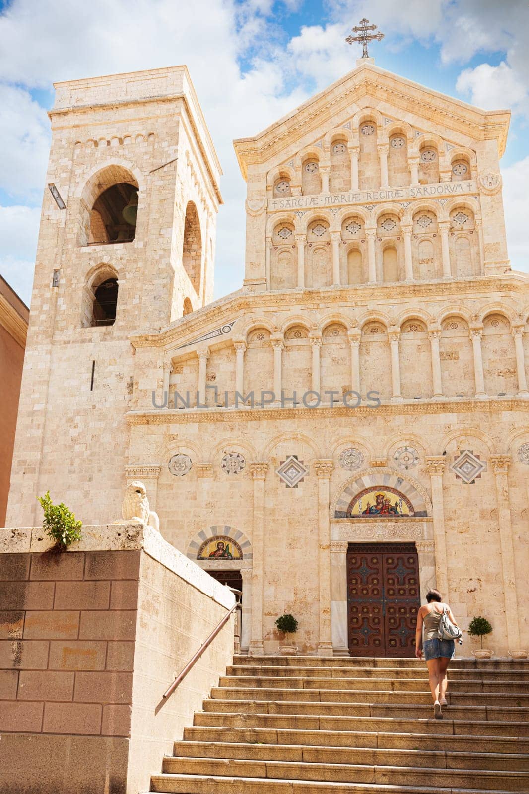 View of the Cathedral of Santa Maria in Cagliari, with a woman climbing the steps. Sardinia, Italy